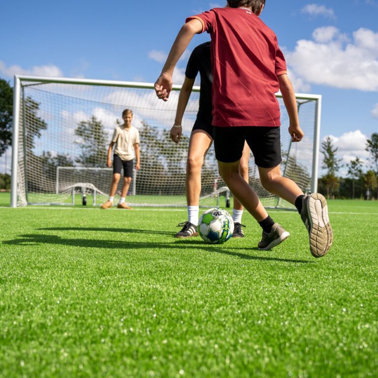 Tre unge drenge spiller fodbold